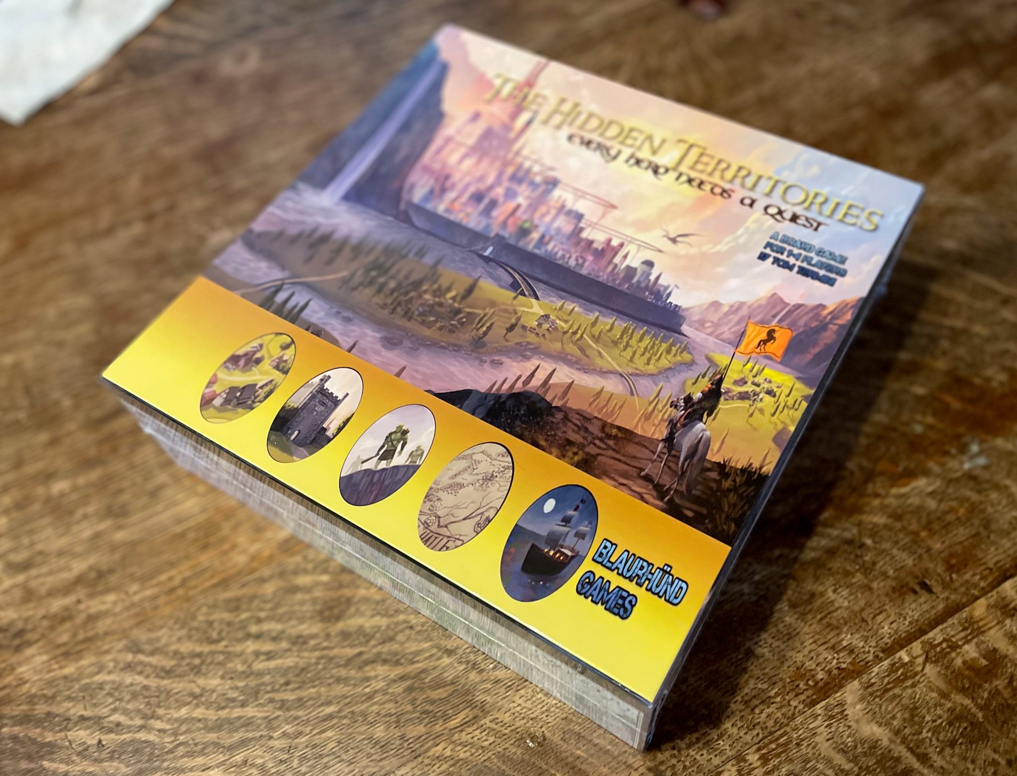 Prototype box for The Hidden Territories on a wooden table.